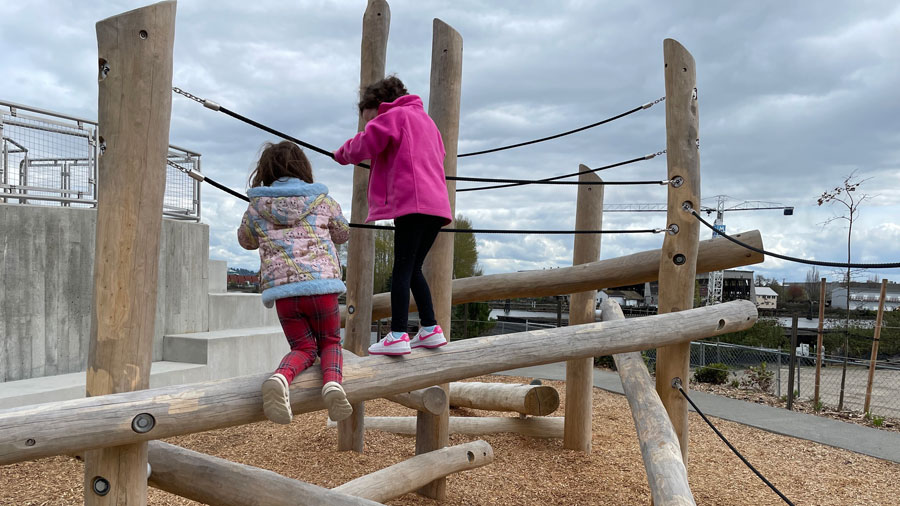 two girls playing on a climbing structure at Melanie's Park in Tacoma