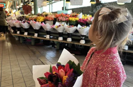 A young girls with a bouquet of flowers at Seattle's Pike Place Market with kids