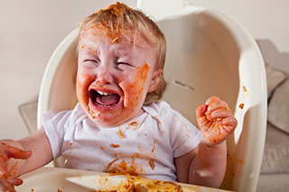 Crying baby eating food