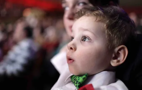 Boy in bow tie watching a show
