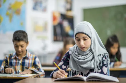 muslim girl writing at school