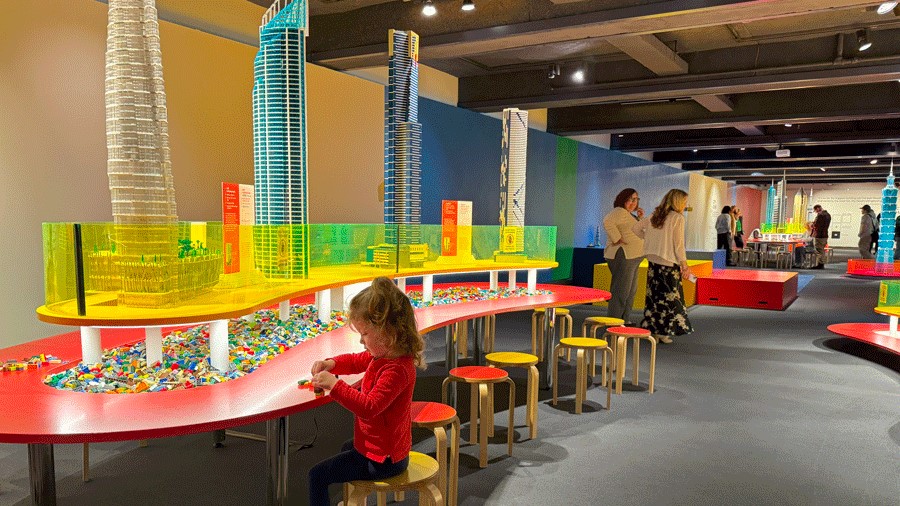 Young girl playing with Lego bricks at the interactive Towers of Tomorrow exhibit