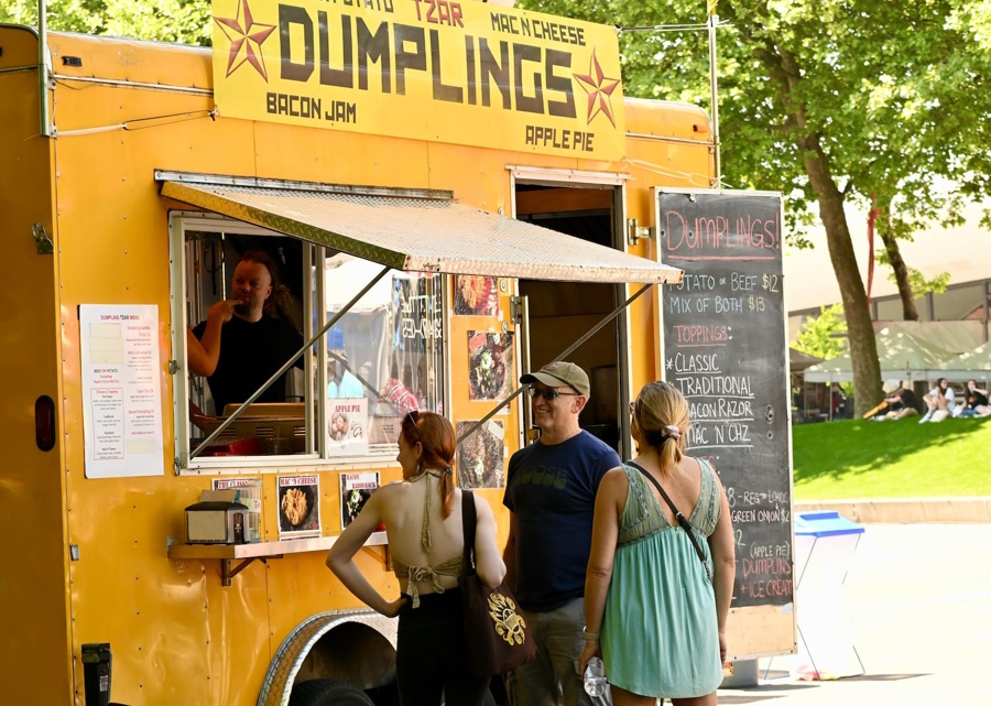 People stand around a yellow food truck at Folklife Festival in Seattle