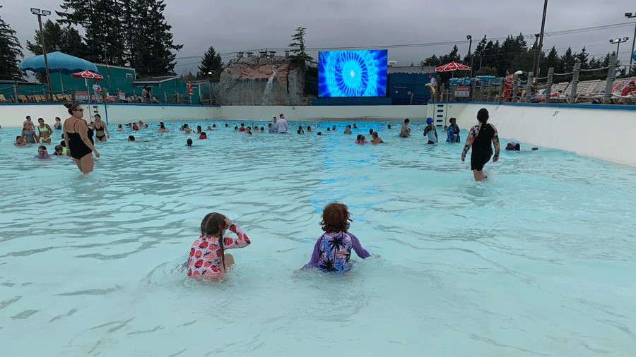 Two kids in the wave pool at Wild Waves Theme & Water Park on a cloudy day
