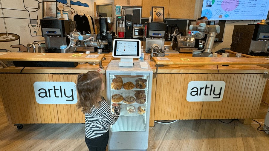 "Young girl orders from a touch screen table at Artly Coffee, a Seattle robot restaurant with espresso drinks"