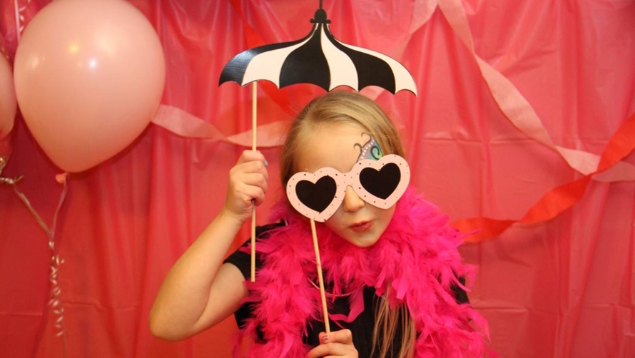 "Young girl posing with props for a photo booth"