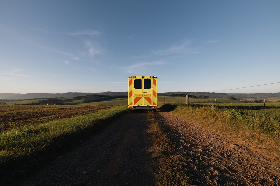 An ambulance driving down a rural road