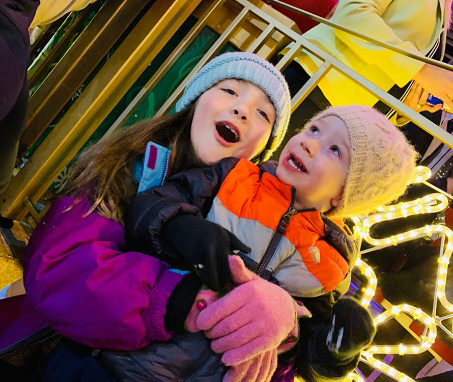 siblings hugging at snowflake lane