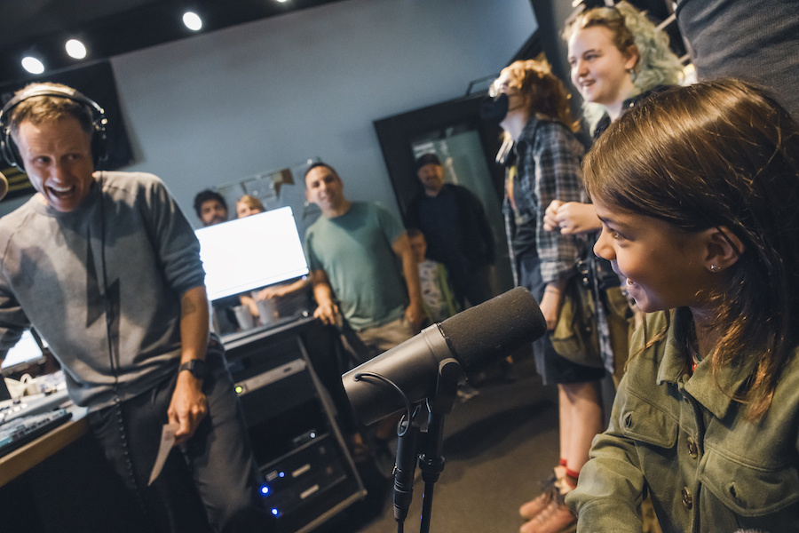 child in DJ booth with host for KEXP's Kids' Day