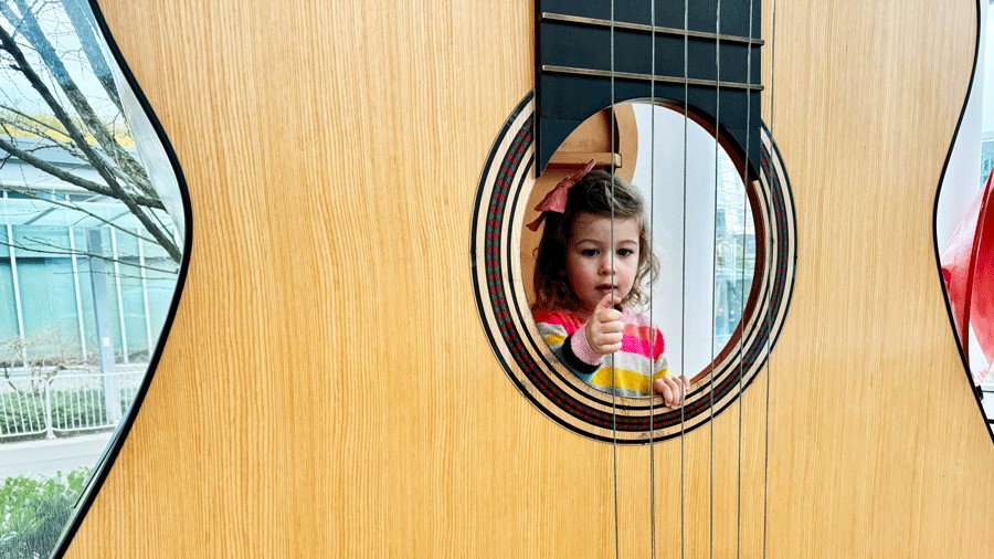 girl experimenting with sound at Pacific Science Center in Seattle, a STEM-based activity for families