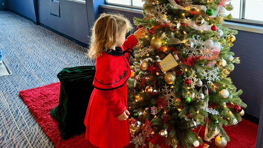 Young girl looking at Christmas tree and holiday decorations onboard the Argosy Christmas Ship