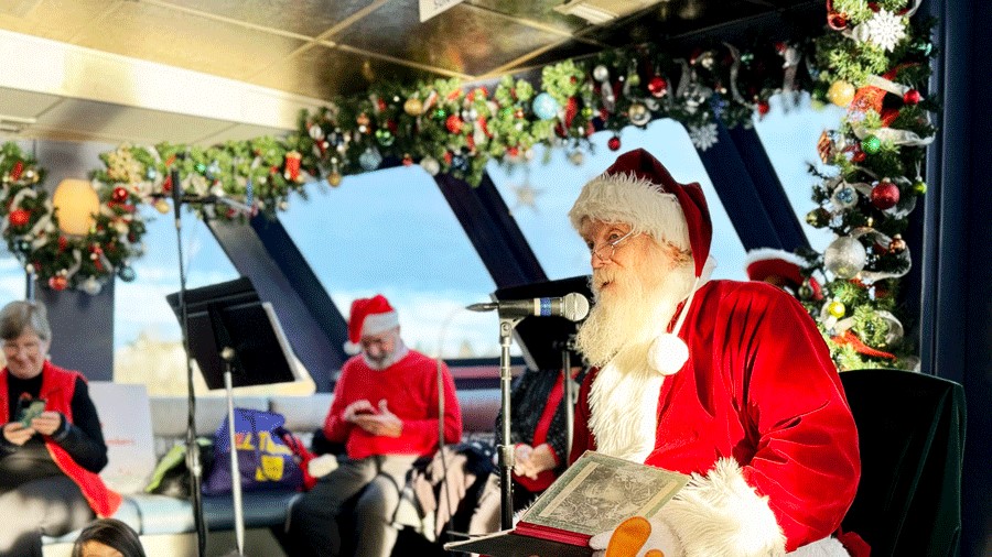 Santa reading "The Night Before Christmas" to young kids on the Argosy Christmas Ship