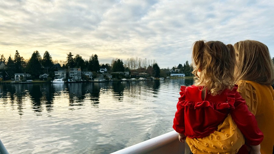 Family watching the water from the outdoor deck of the Argosy Christmas Ship