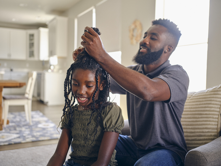 Black dad does his daughter's hair