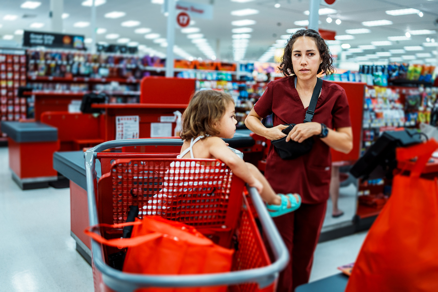 stressed mom in hospital scrubs shops with her baby