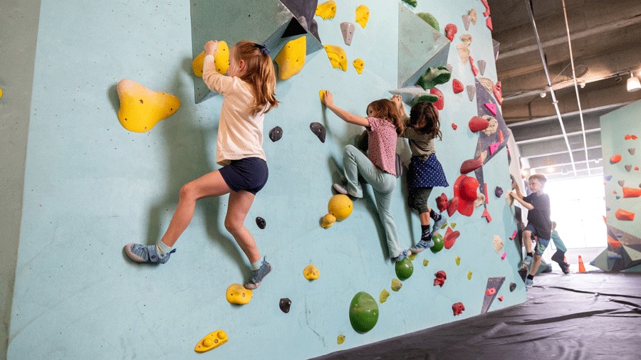 kids climbing during an indoor birthday party at Seattle Bouldering Project