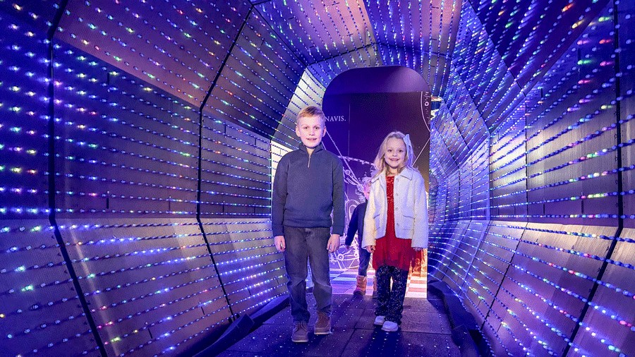 kids in light-up tunnel at Kringle's Inventionasium, an immersive experience for Seattle families during the holidays