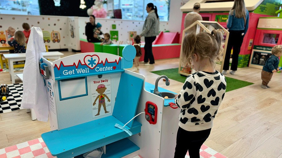 young girl playing at a kids doctor office at Little Pandas Play Cafe, an imaginative play space for families