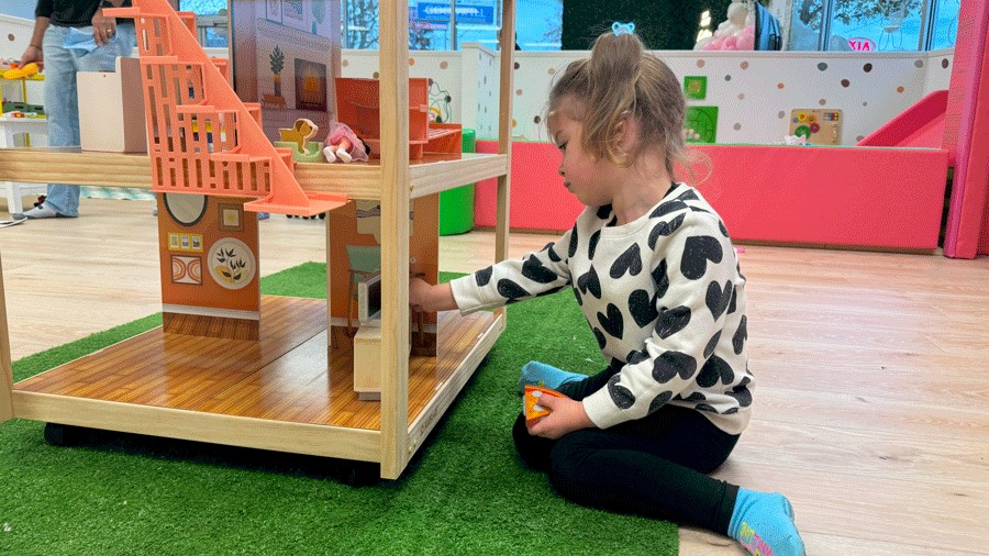 young girl playing with a dollhouse at Little Pandas Play Cafe in Everett