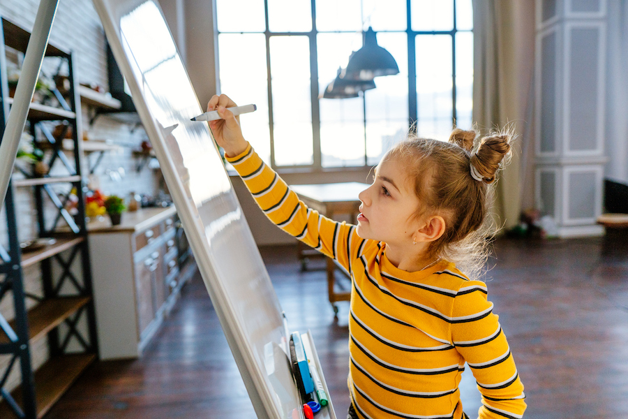 child writing a list of her favorite family meals to help with prep