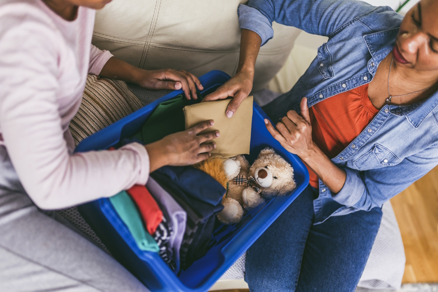 mom and daughter organizing toys and clothing donations