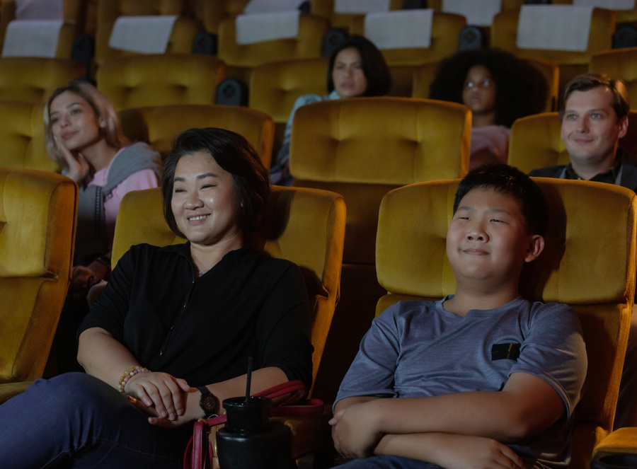 mom and teen son in a movie theater