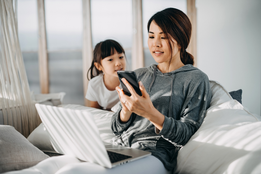 mom using a cell phone while daughter watches 