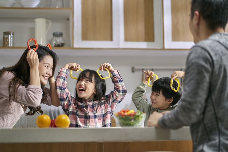 Family holding up peppers having fun with Thanksgiving leftovers