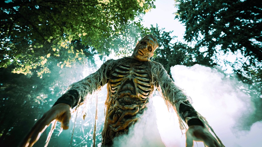 Wild Waves Fright Fest haunted house and woods zombie reaching forward