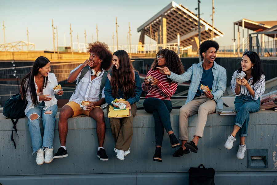 Teens laughing and eating lunch together at school