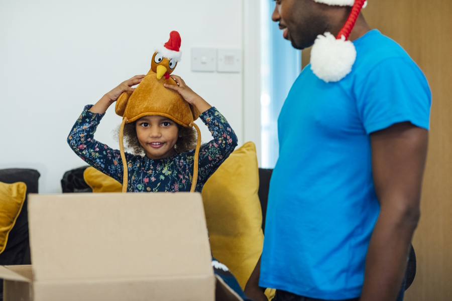 A girl and her father dressing up in silly Thanksgiving hats