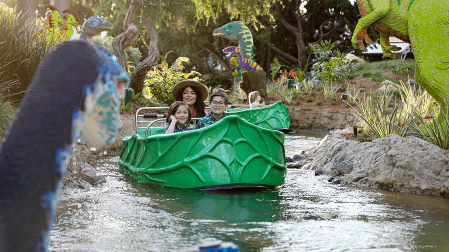 kids on a Legoland dinosaur ride in San Diego during their warm winter vacation with family