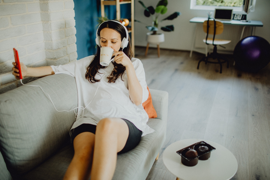 woman on couch listening to a parenting podcast