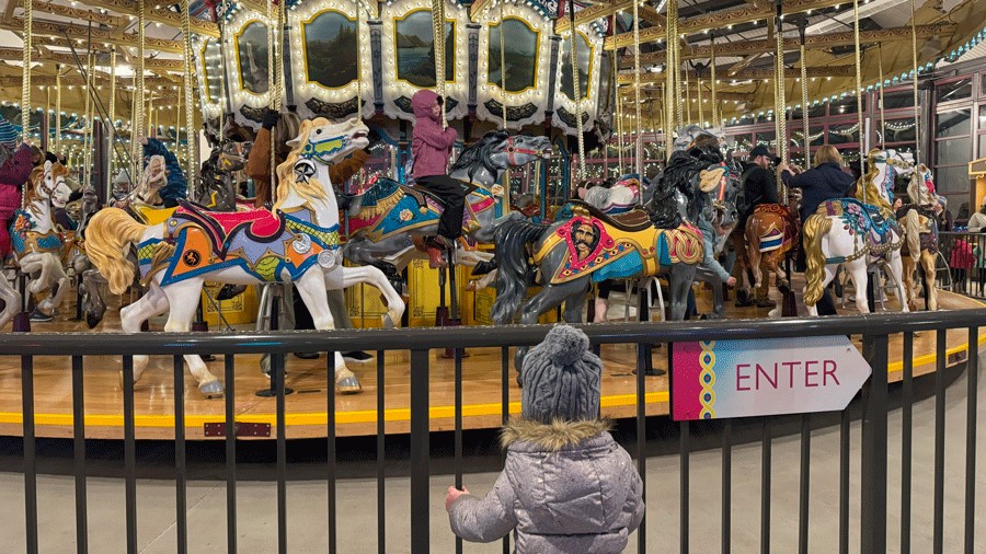 young girl watching historic carousel at the Woodland Park Zoo during WildLanterns