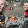 Two mom friends smile for a selfie while camping.