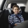 boy smiles in the backseat of a car