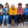 group of teens looking at their phones on social media