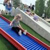 Young girl slides down a roller slide at a new inclusive playground near Seattle