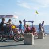 A family riding a covered bike on Alki beach