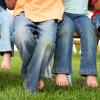 Young children sitting on a bench in the grass all wearing jeans. Target Denim Take Back Event