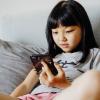 young girl looking at a smart phone using social media