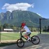 Young boy rides a bike on a Seattle-area pump track with mountain views in the background at Torguson Park in North Bend 