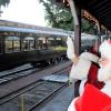 During a Santa train ride, Santa waves as the Northwest Railway's Santa Limited Train rolls into the station