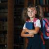 Young girl wearing a backpack getting ready to go to school