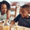 Two siblings eating breakfast together