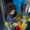 child checks out a bountiful CSA box