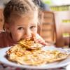 child eating potato and cheese gozleme on wooden table. Traditional stuffed pancakes in Alanya, Turkey. 