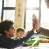 Boy and teacher giving a high five and have a positive student-teacher relationship