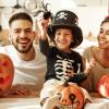 Family sitting together on Halloween with pumpkins and decorations