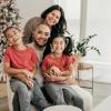 family smiling together for a holiday photo 